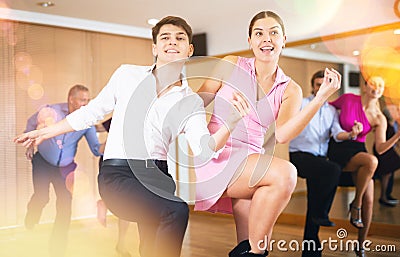 Young couple dancing jive during group training Stock Photo