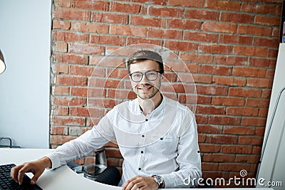 Positive unshaven office worker looking at the camera Stock Photo