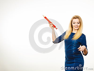 Positive woman holds big pencil in hand Stock Photo