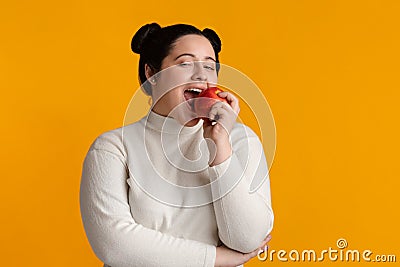 Positive Young Plus Size Girl Eating Red Apple Stock Photo