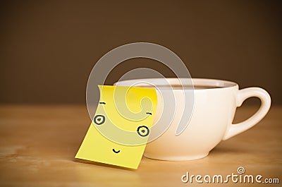 Post-it note with smiley face sticked on a cup Stock Photo