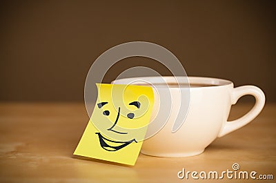 Post-it note with smiley face sticked on a cup Stock Photo