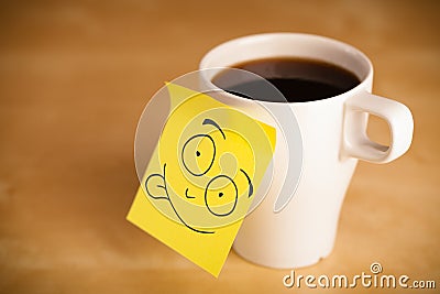 Post-it note with smiley face sticked on a cup Stock Photo