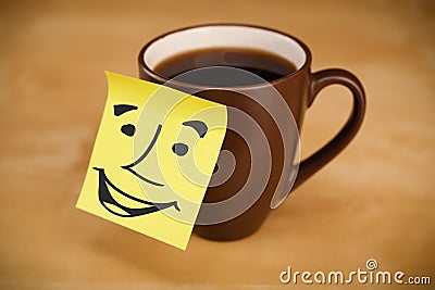 Post-it note with smiley face sticked on a cup Stock Photo