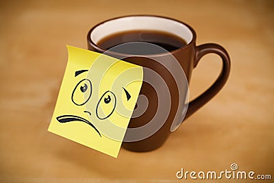 Post-it note with smiley face sticked on cup Stock Photo