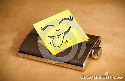 Post-it note with smiley face sticked on hip flask Stock Photo