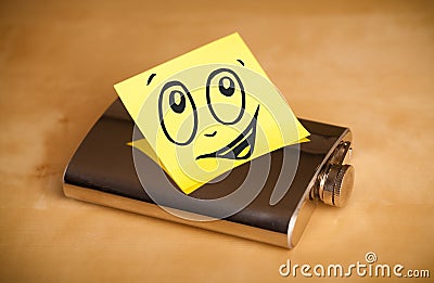 Post-it note with smiley face sticked on hip flask Stock Photo