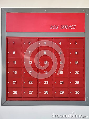 Post office mailbox box service screen white text number one to thirty on front red steel with key Mortise lock, strack in the row Stock Photo