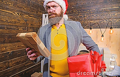 Post for santa claus. Man bearded hipster wear santa hat hold bunch of letters and gift box. Gifts delivery service Stock Photo