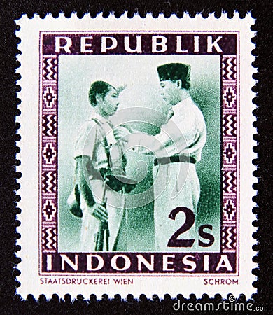 Postage stamp Indonesia, 1949. President Soekarno decorates a soldier Editorial Stock Photo