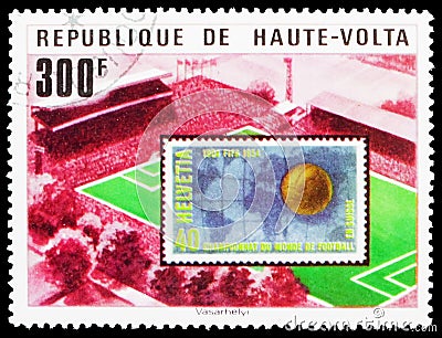 Postage stamp printed in Upper Volta (Burkina Faso) shows Stadium and Swiss stamp, World Cup Football serie, circa 1977 Editorial Stock Photo