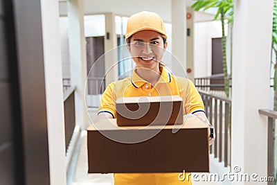 Postal lady delivers the mailbox in front of the house Stock Photo