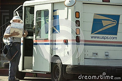 Postal worker with package at truck Editorial Stock Photo