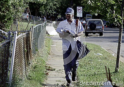 Postal worker walking delivering mail Editorial Stock Photo