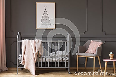 Poster above kid`s bed with blanket next to grey armchair with p Stock Photo