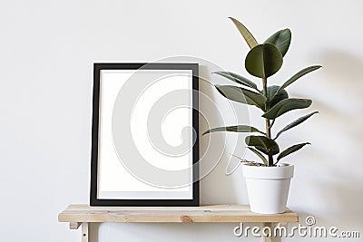 Poster in black frame in white stylish modern interior on a wall above green sofa. Design template mockup Stock Photo