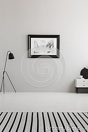 Poster on grey wall in living room interior with striped carpet Stock Photo