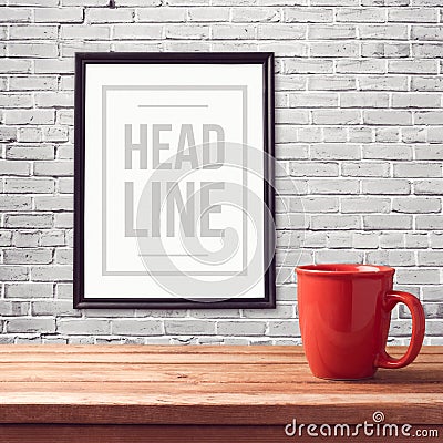 Poster mock up template with red cup on wooden table over brick white wall Stock Photo
