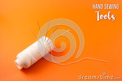 poster or postcard template with text hand sewing tools, needle and thread on orange background Stock Photo