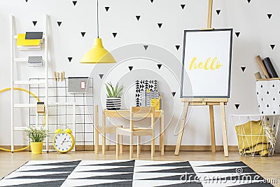 Poster on a wooden easel and a small desk for children in a whit Stock Photo