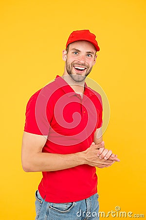 Postman delivery worker. Man red cap yellow background. Delivering purchase. Already ready. Easing your business Stock Photo