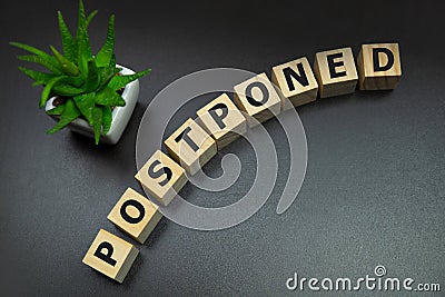 Postponed - words from wooden blocks with letters, postponed concept, top view gray background Stock Photo