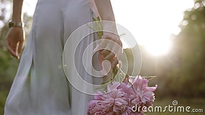 Postérieur dépistant la longueur d'une femme dans des vêtements lumineux marchant par le pré vert avec le bouquet des fleurs rose clips vidéos Postérieur dépistant la longueur d'une femme dans des vêtements lumineux marchant par le pré vert avec le bouquet des fleurs rose clips vidéos