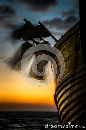 Pot flags blow in the wind on a fishing boat at dawn Stock Photo