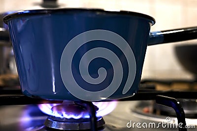Pot on the gas stove with blue flamme at the kitchen Stock Photo