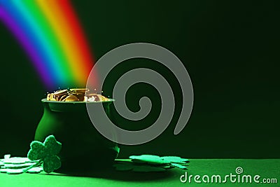 Pot with gold coins and clover leaves on table, space for text. St. Patrick`s Day celebration Stock Photo