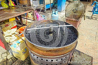 Pot with hot pebbles to roast chestnuts, street food in Chinatown, Kuala Lumpur Editorial Stock Photo