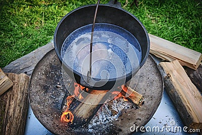 Pot of soup on a summer day, a tourist camp. A cauldron with a piece of meat in broth boiling on fire Stock Photo