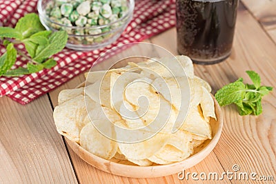 Potato chips and green nuts with ice cola. Stock Photo