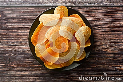 Potato chips over wooden background. Salty crispy snack Stock Photo
