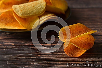 Potato chips over wooden background. Salty crispy snack Stock Photo