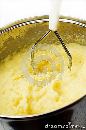 Potato mash with masher. Stock Photo