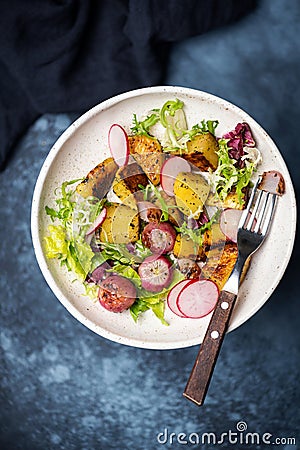 Potato salad with roasted radishes and greens Stock Photo