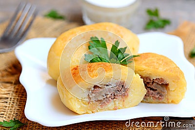 Potato zrazy with a meat filling on a white plate and a vintage wooden table. Traditional Ukrainian zrazy recipe. Closeup Stock Photo