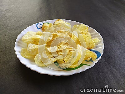 Potatochips in a plate, blackbackground Stock Photo