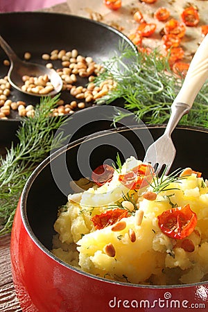 Potatoes boiled with fried pine nuts and sun dried tomatoes Stock Photo