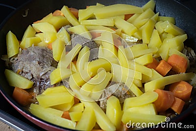 Potatoes, carrots and chicken were baked in a black pan Stock Photo