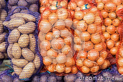 Potatoes and onions in mesh on the market Stock Photo