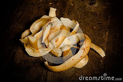 Potatoes peelings on old wooden background. Toned Stock Photo