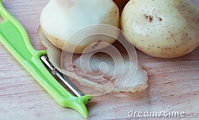 Potatoes, Peelings and Peeler. Stock Photo