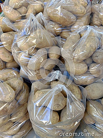 Potatoes in plastic bags stocked for sale. Stock Photo