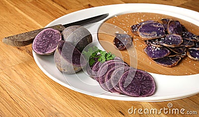 Potatoes variety `Bleue d`Artois` cut in slices Stock Photo