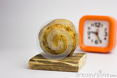 Potatoes on a white background regain the clock. Stock Photo