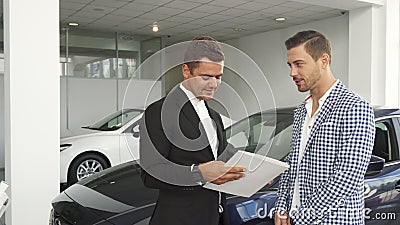 Potential buyer and seller read the characteristics of the car Stock Photo