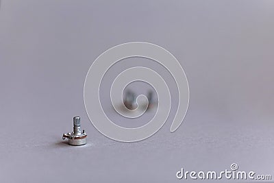 Potentiometers stand on the gray background. Many Potentiometers. Macro close up of electronic component potentiometer Stock Photo