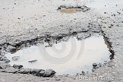 Potholes. Potholes dangerous to motorists and pedestrians. Stock Photo